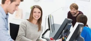 Smiling young businesswoman in a busy office
